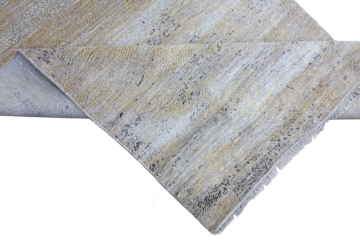 Corner view of light blue and cream area rug with short fringe and textured weave.