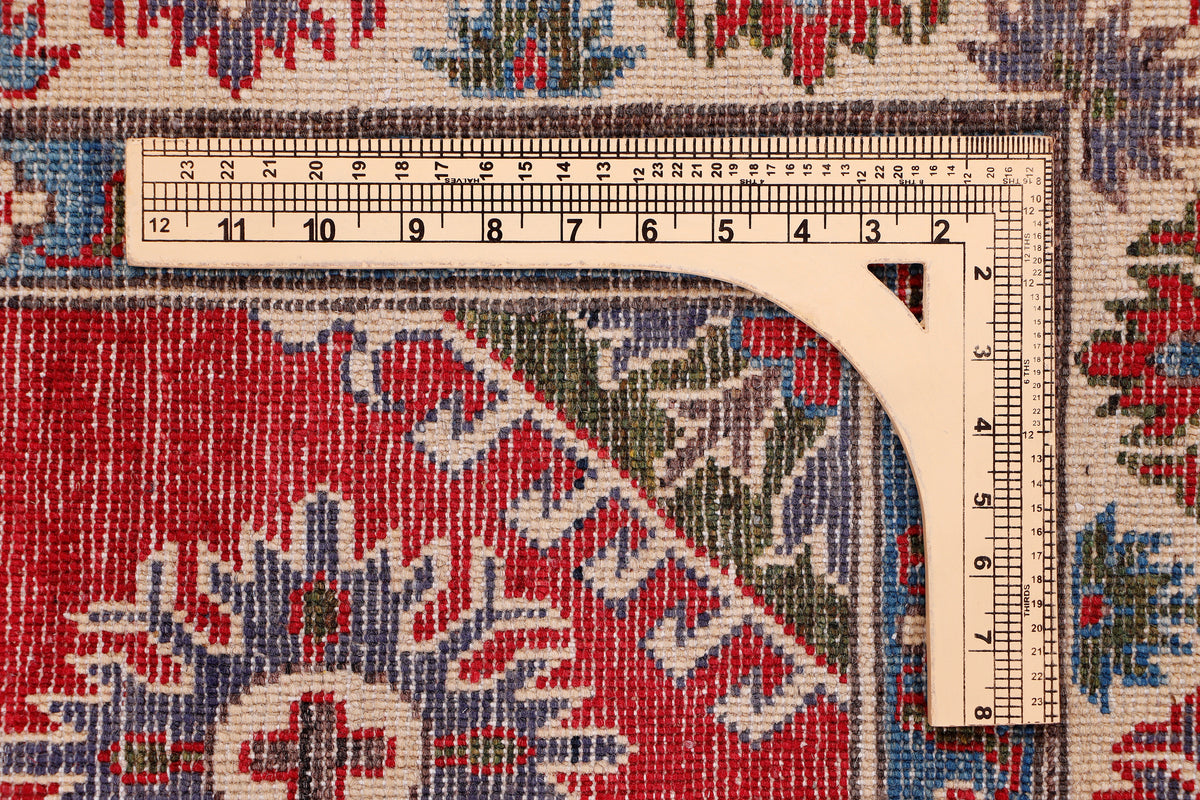 Rug close-up with ruler measuring pile on red and blue patterned surface