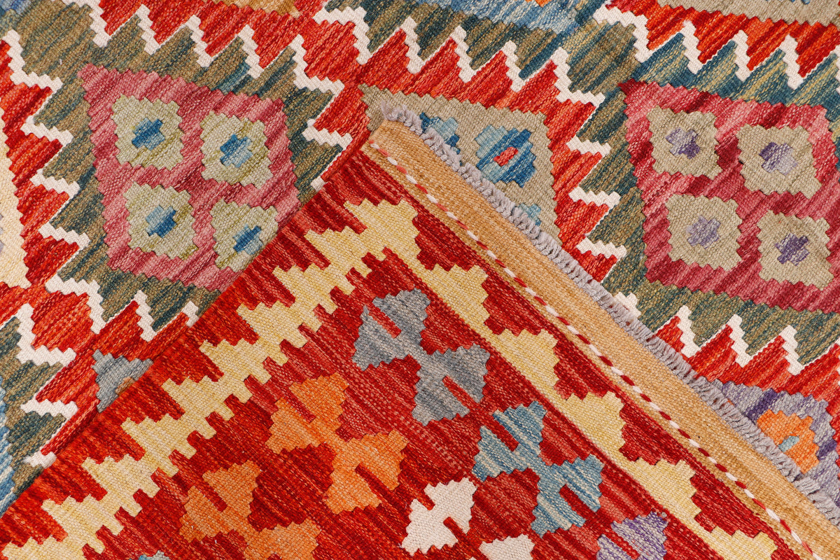 Diamond kilim rug detail showing red, orange, blue, and pastel motif threads