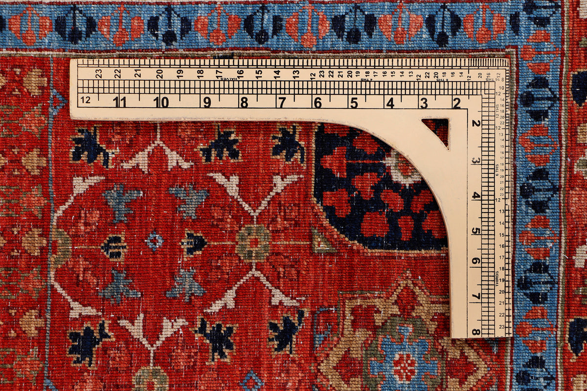 Measured section of red wool rug with blue border and symmetrical geometric pattern
