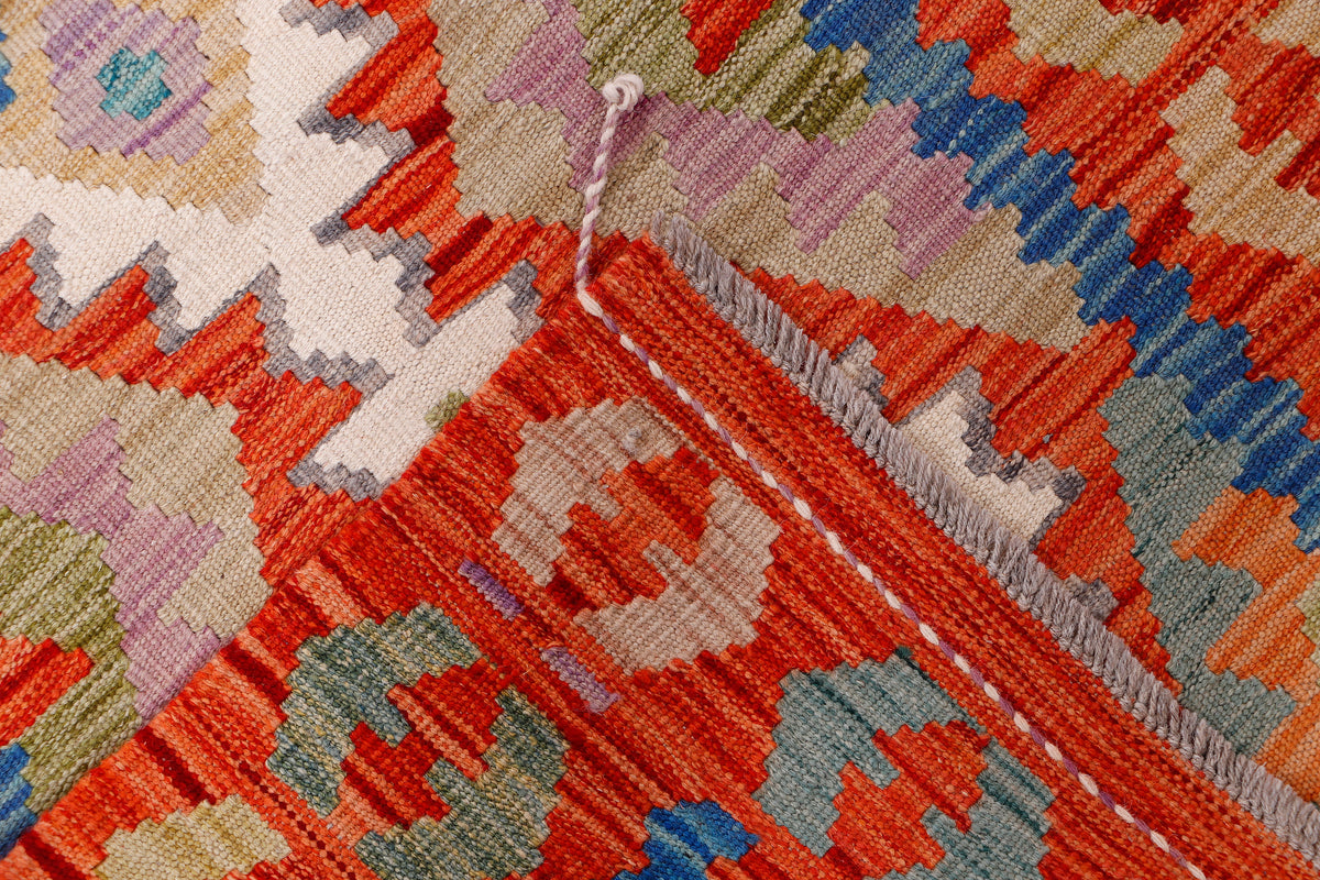 Kilim rug weave close-up with orange, blue, green, and pink geometric accents