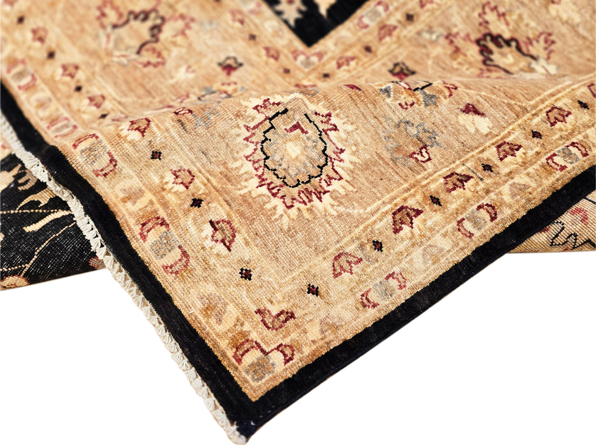 Afghan rug corner detail with beige field, red and blue accents, and black edging.