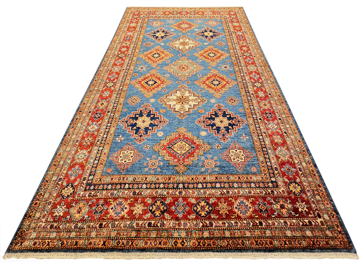 Rectangular blue area rug with red border and geometric medallion pattern.