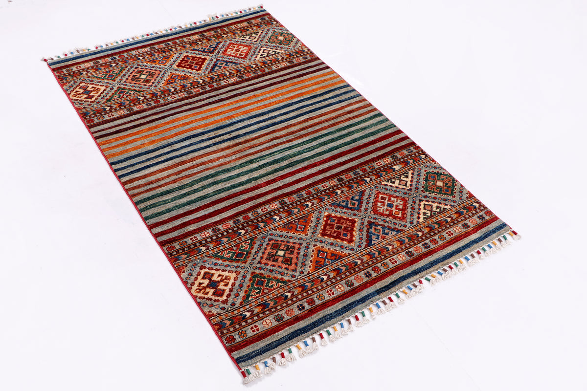 Multicolor rectangular rug with medallion design, striped field, and fringe borders
