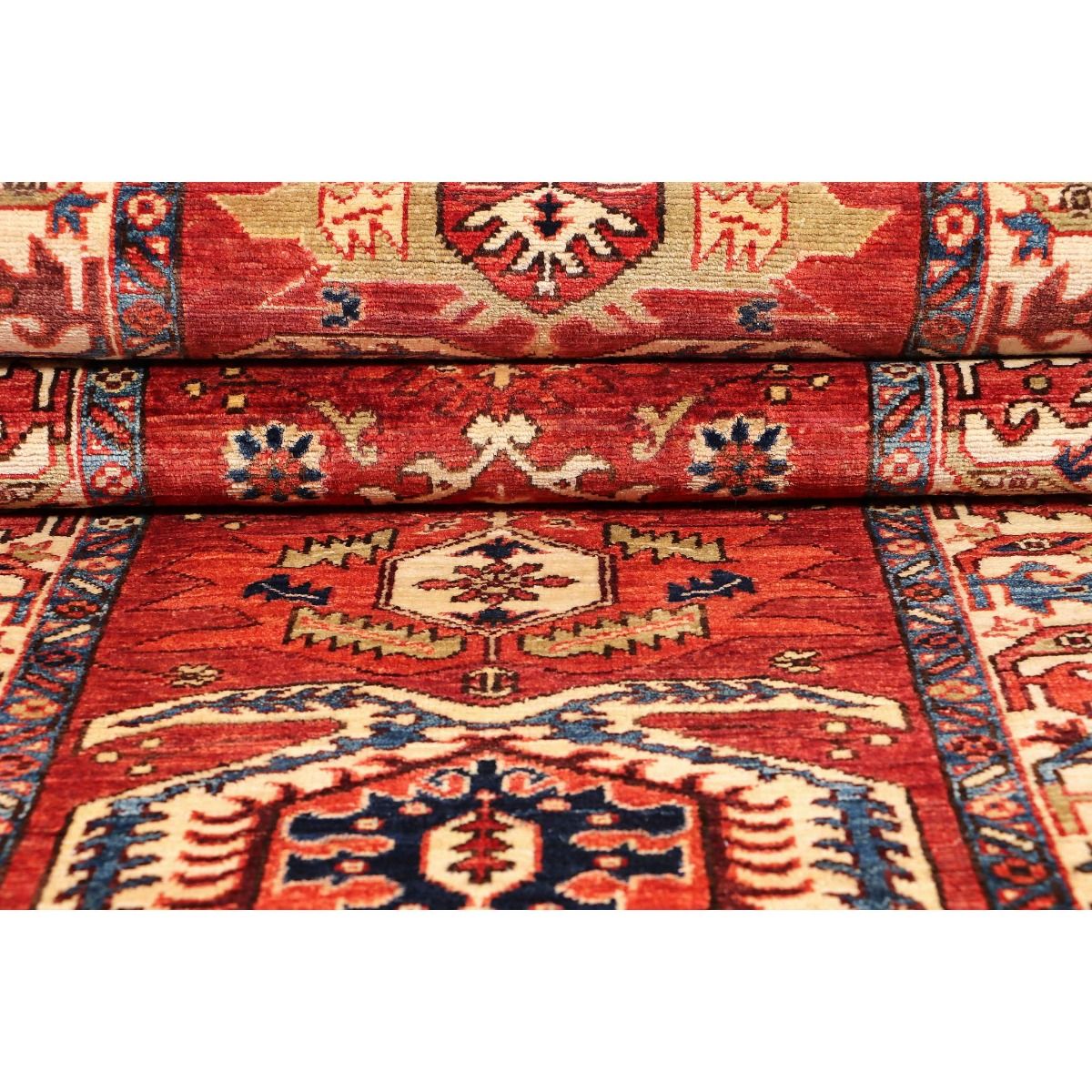 Red Kazak runner rug detail with stacked borders and cream geometric motifs