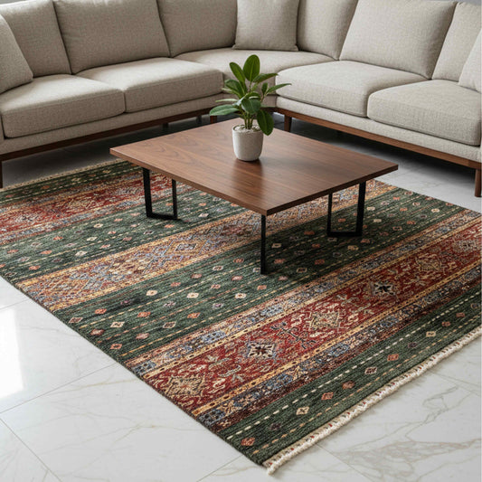 Multicolor patterned area rug with green field, red accents, and cream fringed edges