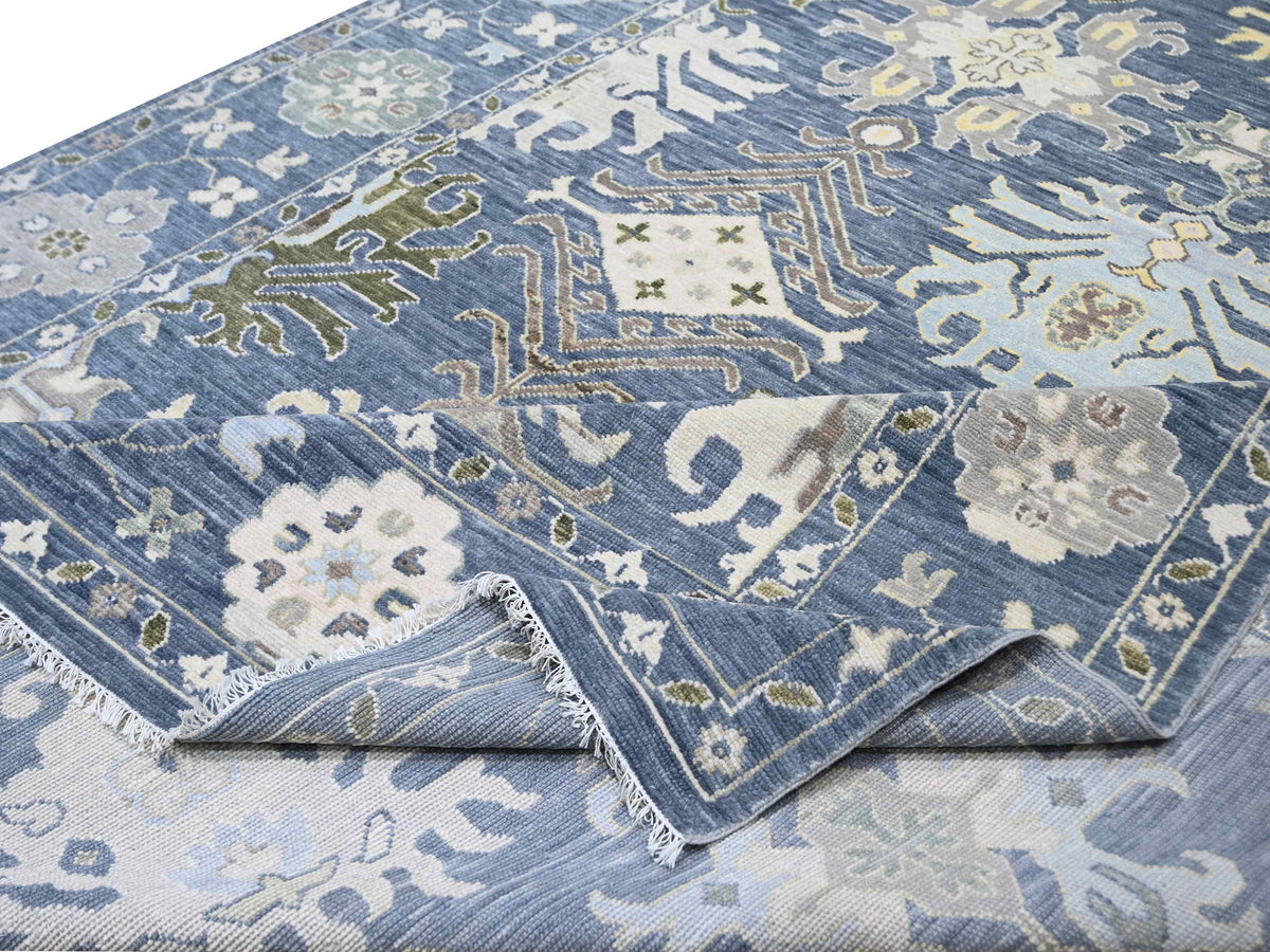 Oushak rug with blue and cream geometric floral pattern, folded corner close-up