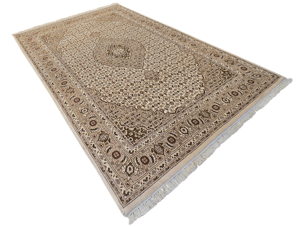 Beige and brown area rug with central medallion, detailed border, and short fringe.