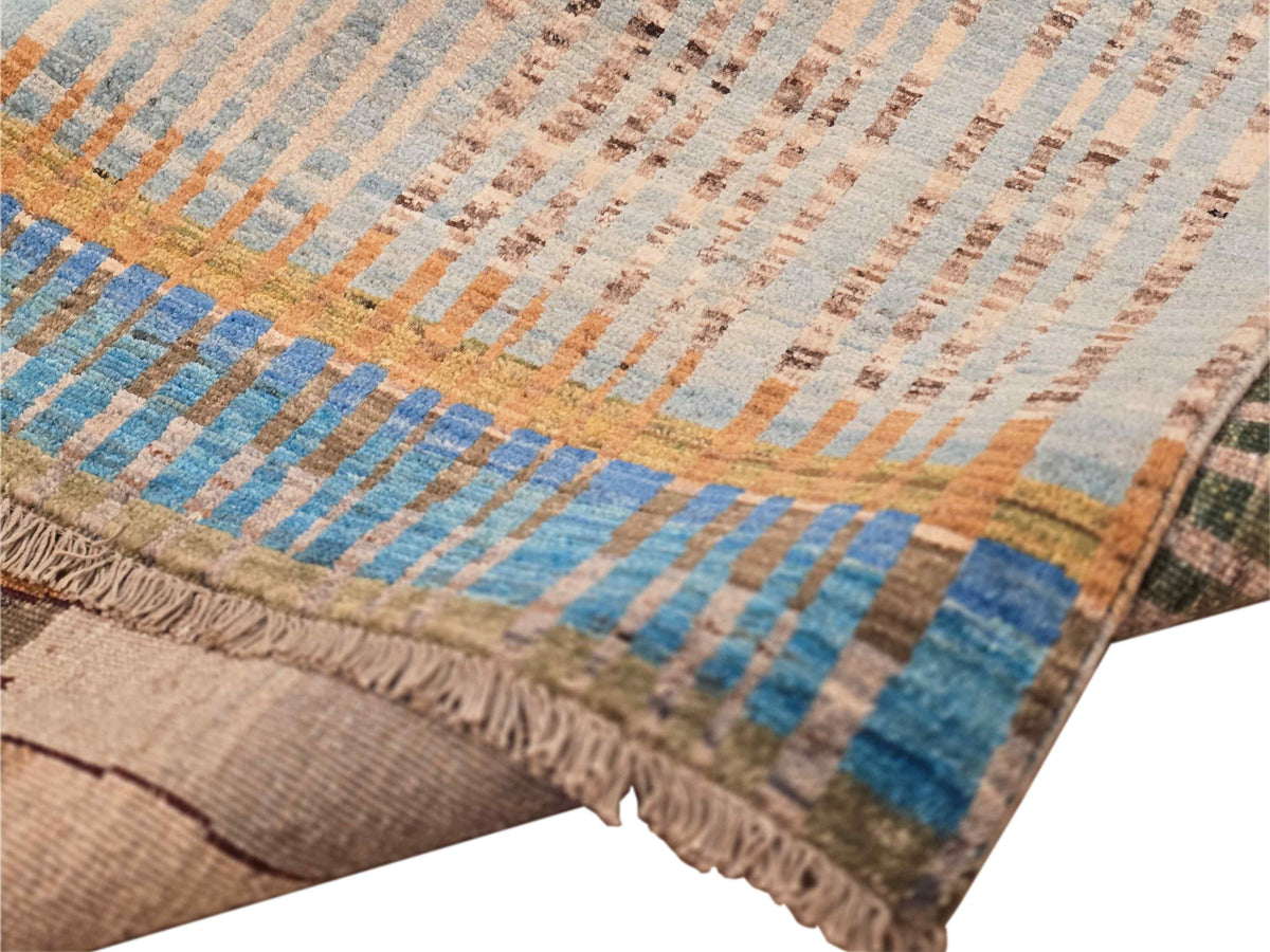 Close-up of multicolor rug border with zigzag stripes and frayed fringe along the edge.