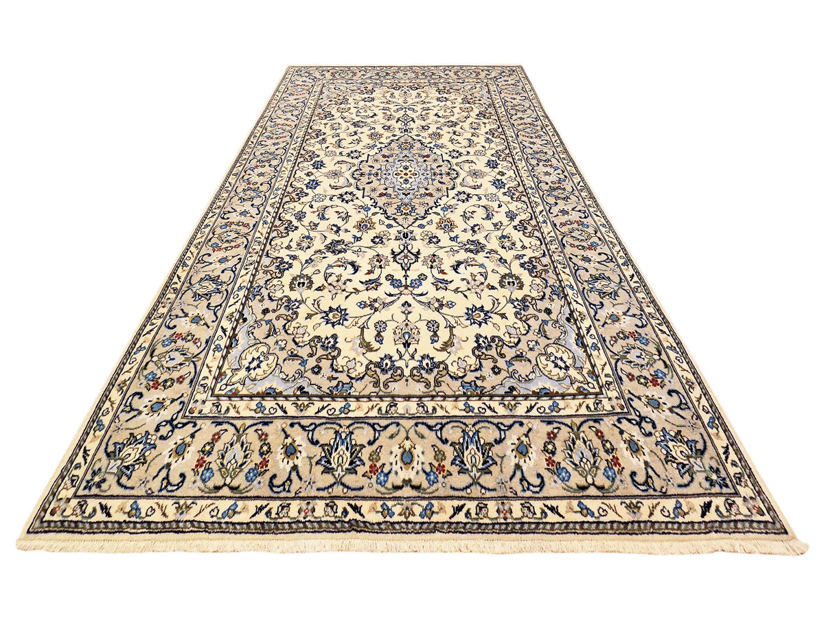 Kashan-style area rug with blue center medallion, cream field, and decorative border