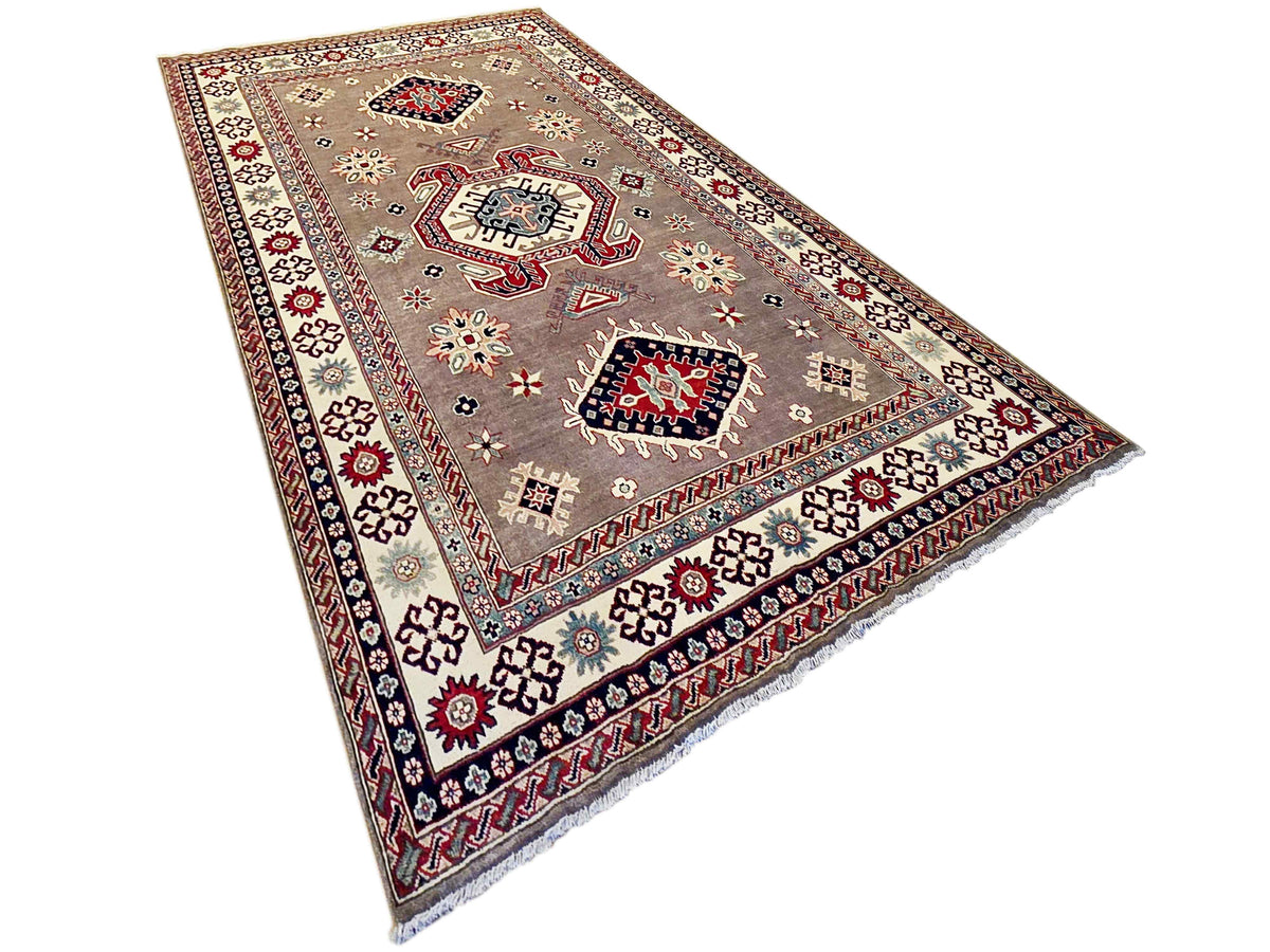 Kazak rug with beige-gray field, red and navy medallions, and decorative floral motifs