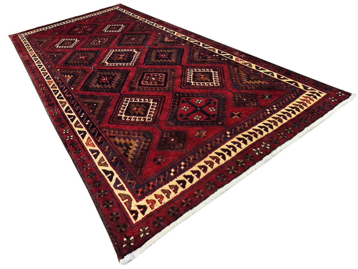 Red and navy geometric area rug with cream edge trim and patterned panels