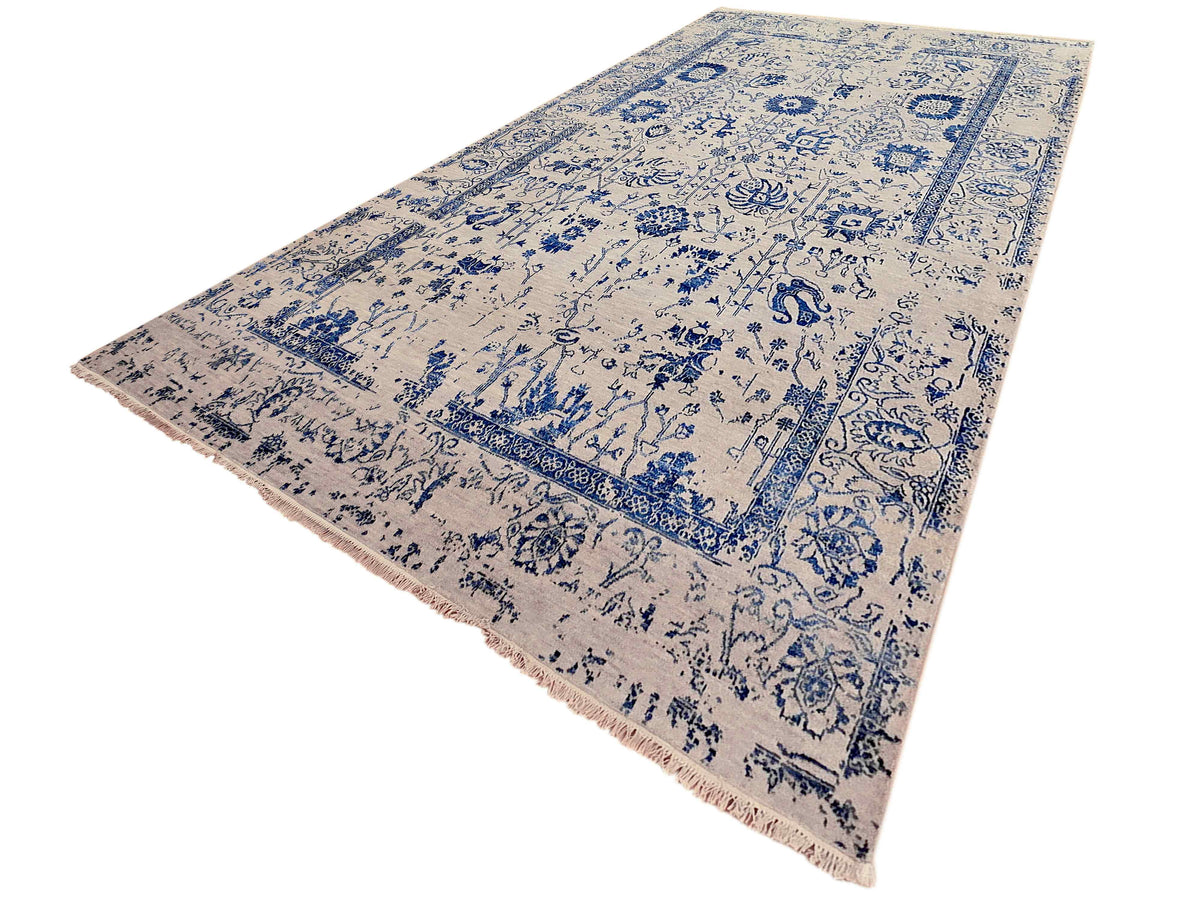 Flat-lay beige and blue patterned area rug with fringed edge