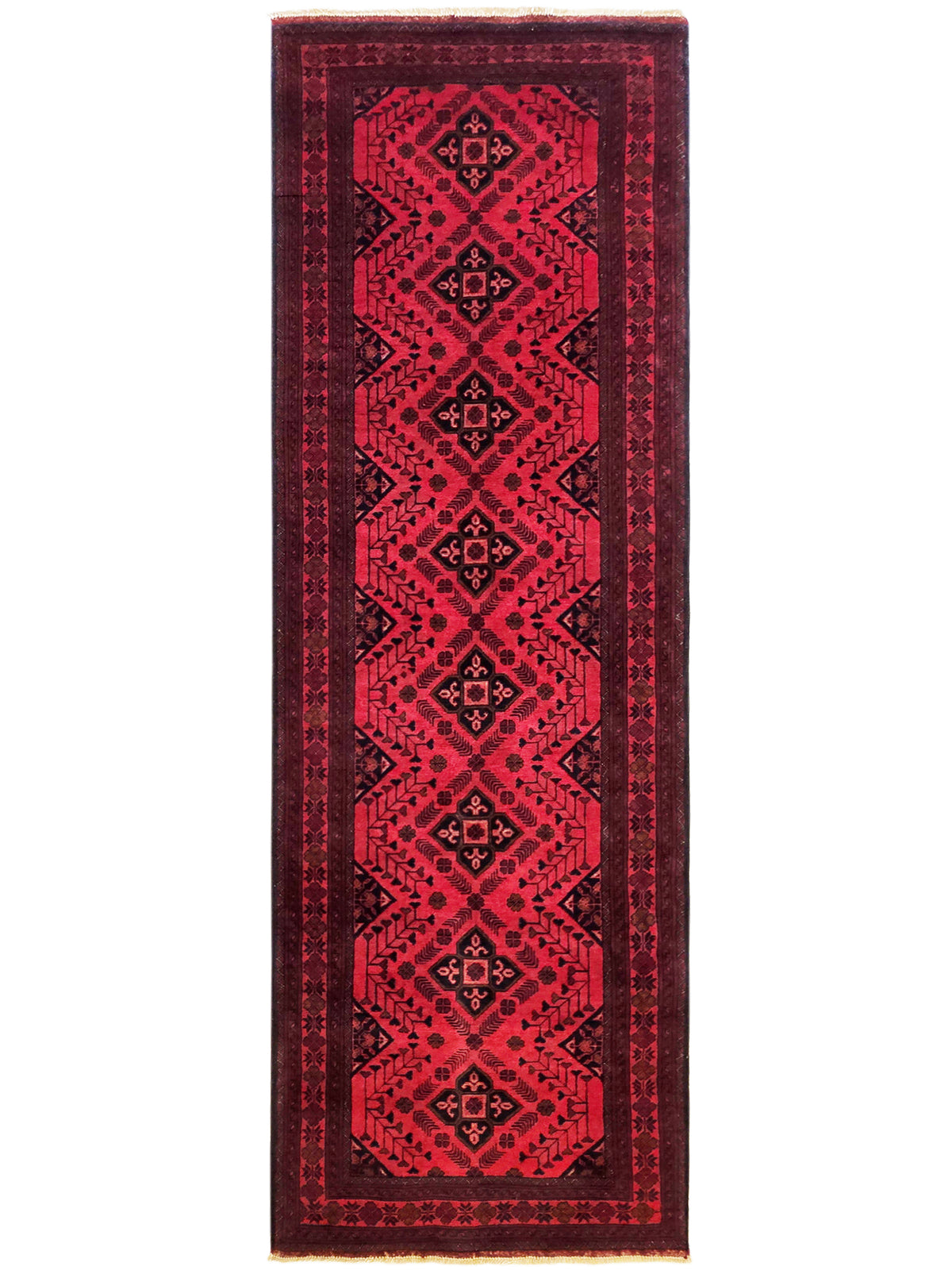 Narrow red rug with repeating geometric border and fringe on sides