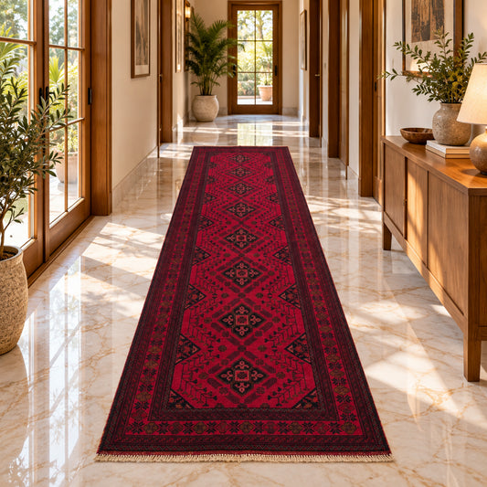 Red geometric rug runner with central diamond motifs and fringed ends