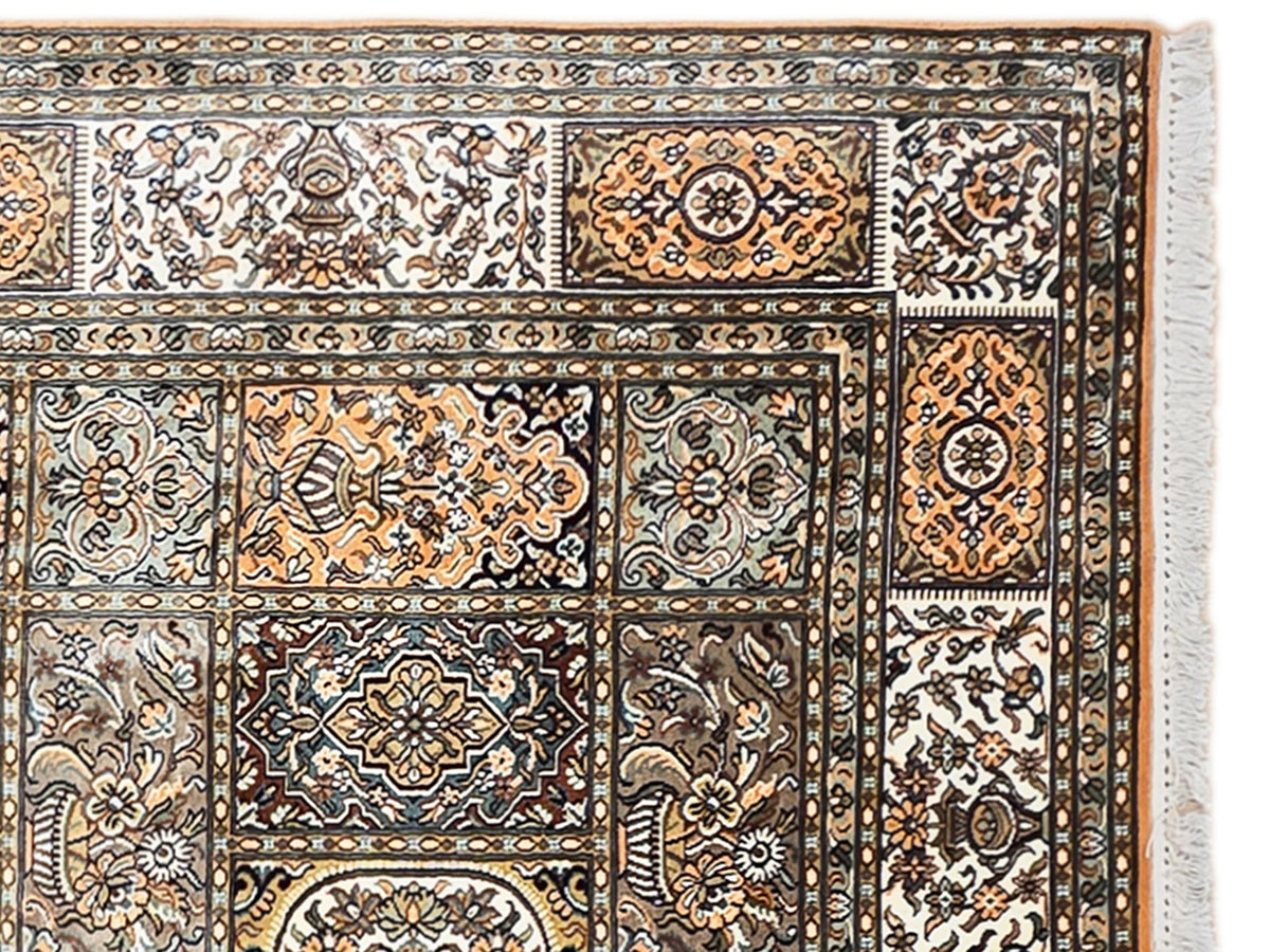 Silk rug with ornate floral and geometric border, multicolor on a light ground.