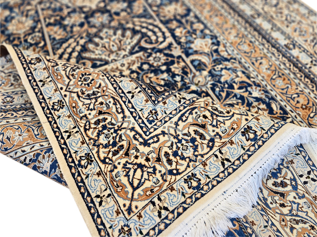 Close-up of navy and beige rug design with decorative border and fringe