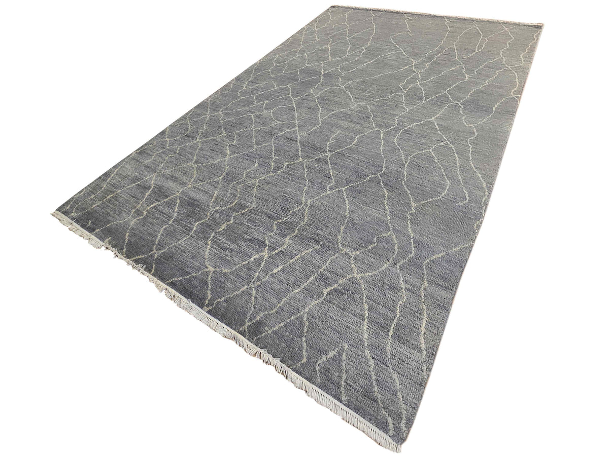Grey area rug with crackled geometric lattice pattern and fringed edges.