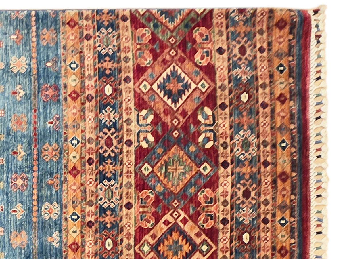 Khorjin-style rug close-up with multicolor geometric medallions and trimmed border edge.