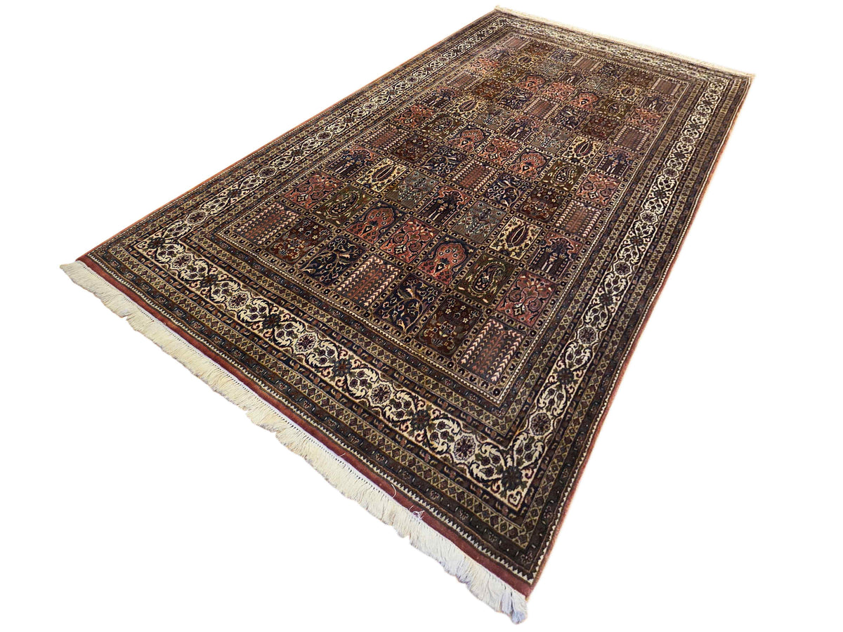 Multicolor Qum-style rug laid flat with central medallion and cream fringe edges
