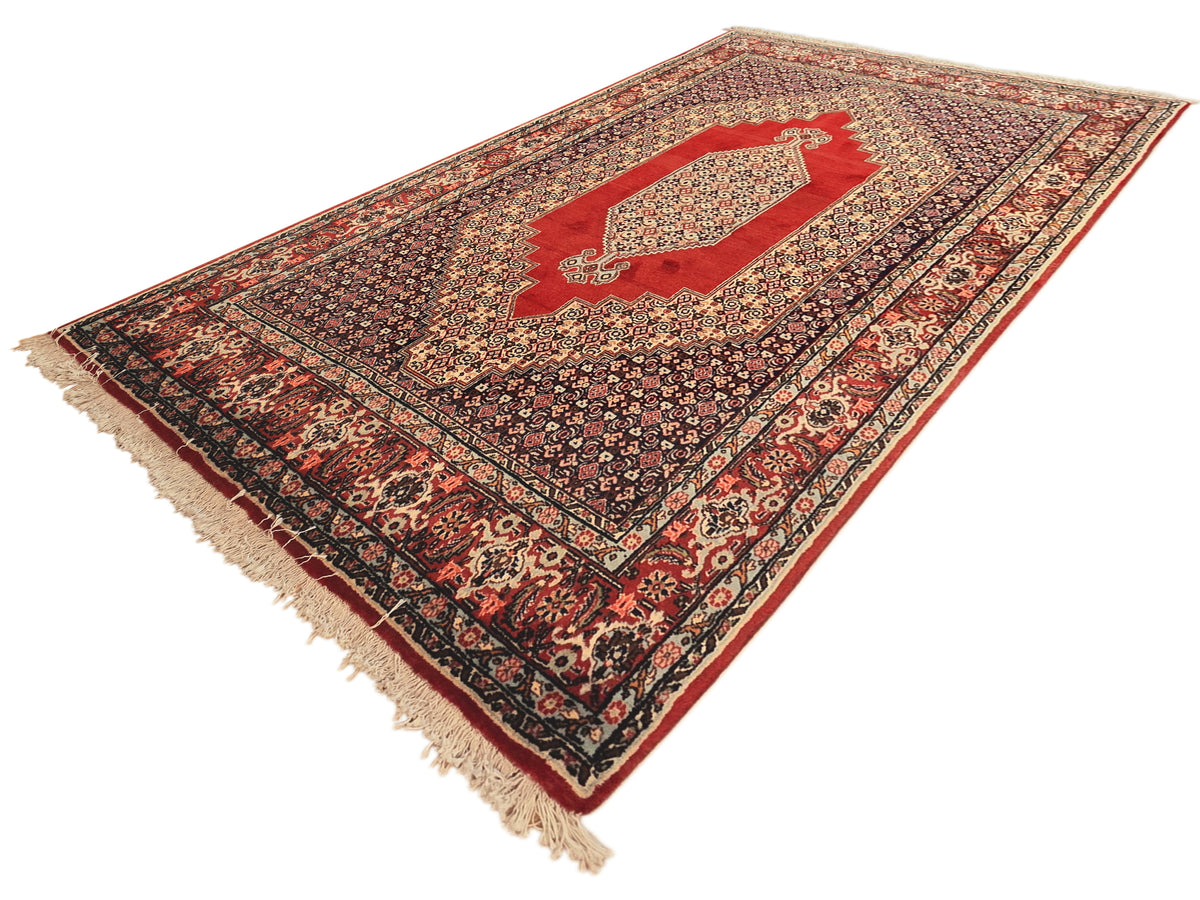 250x142 cm rug with red and navy floral geometric pattern and cream fringe ends