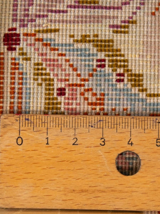 Tight-weave rug detail with cream ground and red/blue floral motifs, measured