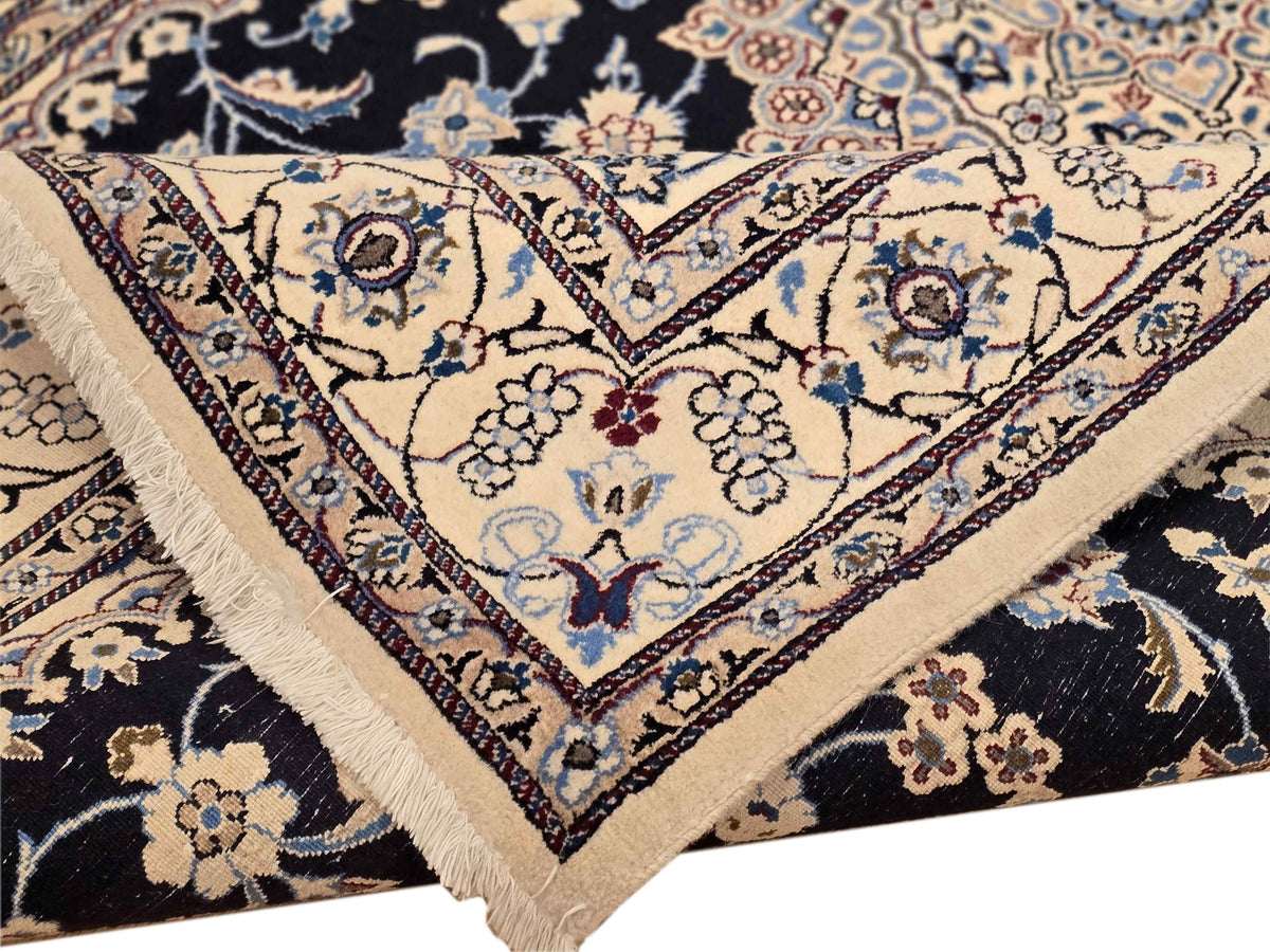 Close-up of Nain rug corner with blue floral motifs and cream geometric edging