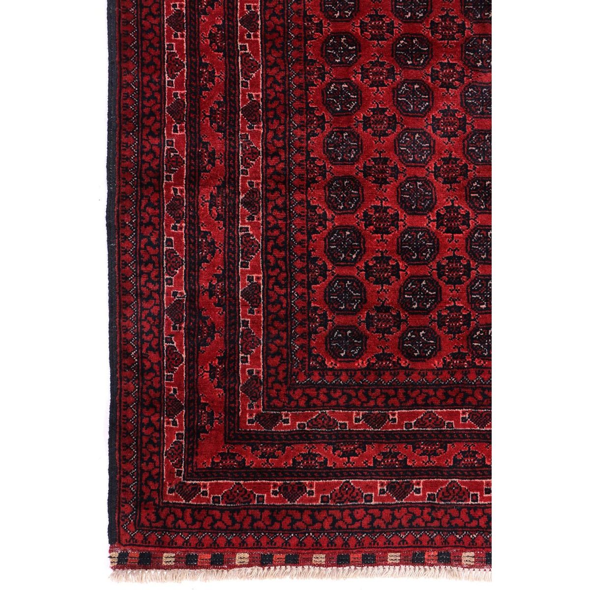 Red Bukhara rug close-up with repeating medallions and striped border bands