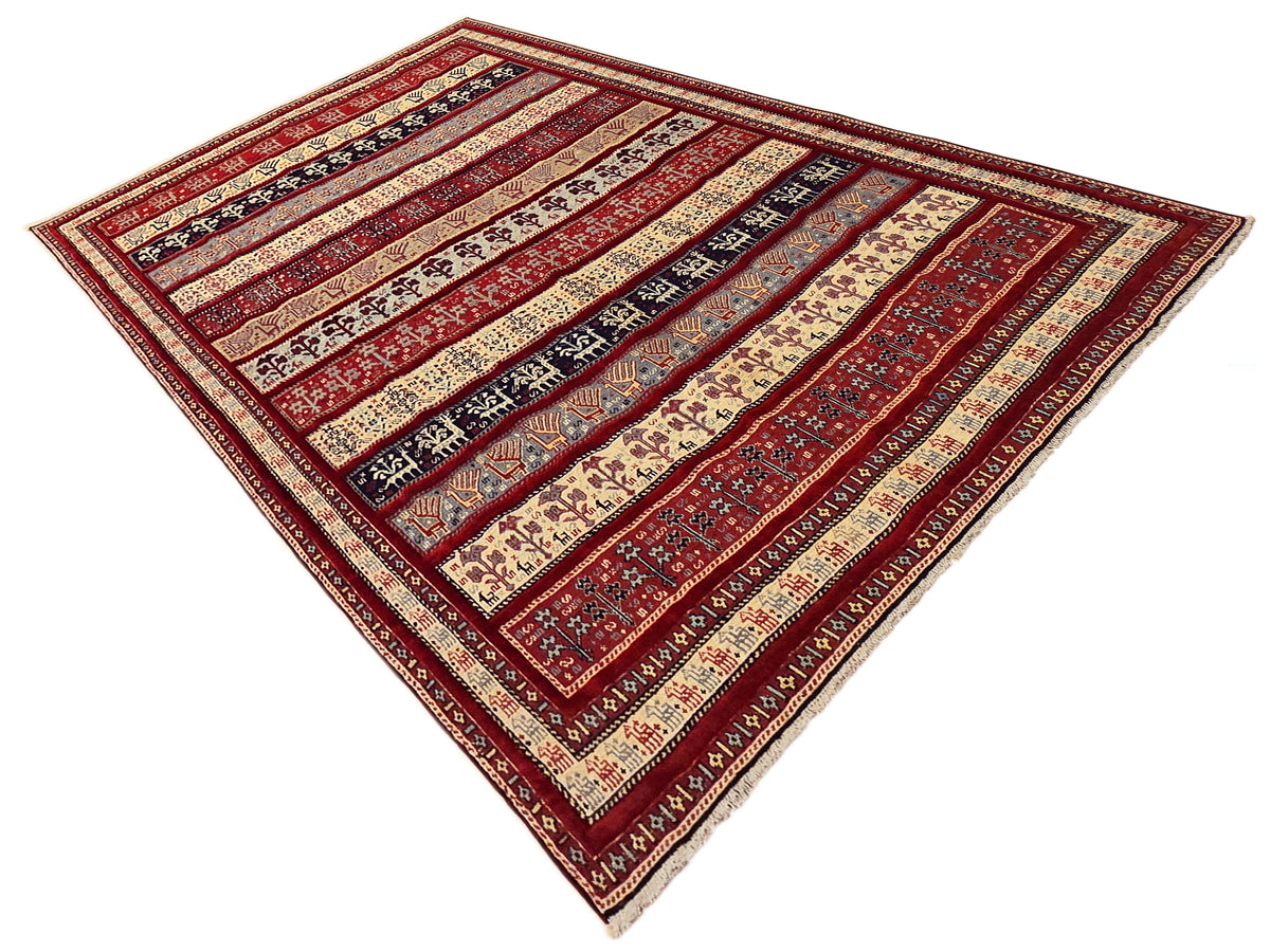 Geometric area rug with red field, cream stripes, and dark navy motifs