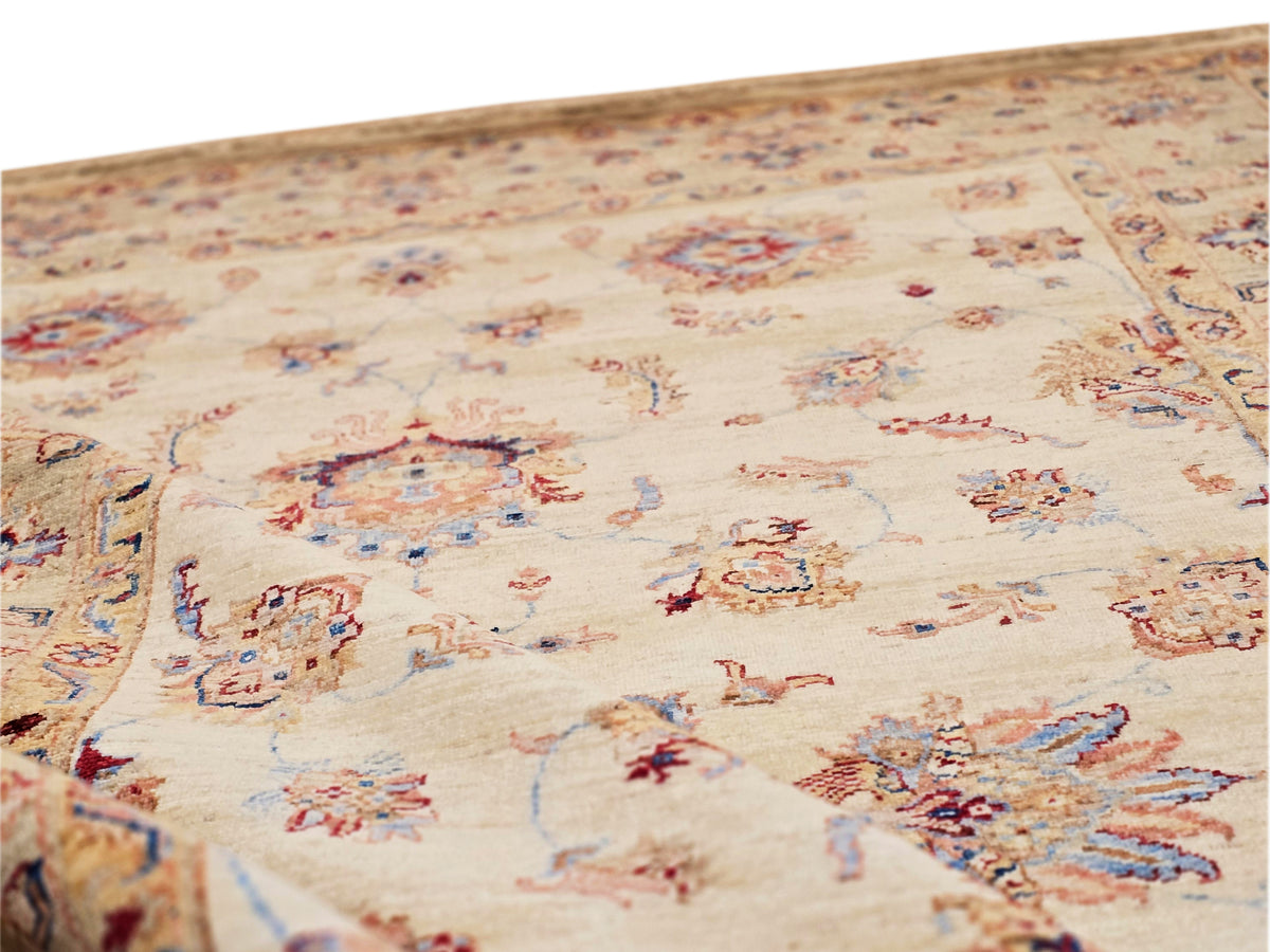 Close-up of cream rug with scattered blue, red, and tan floral and geometric motifs