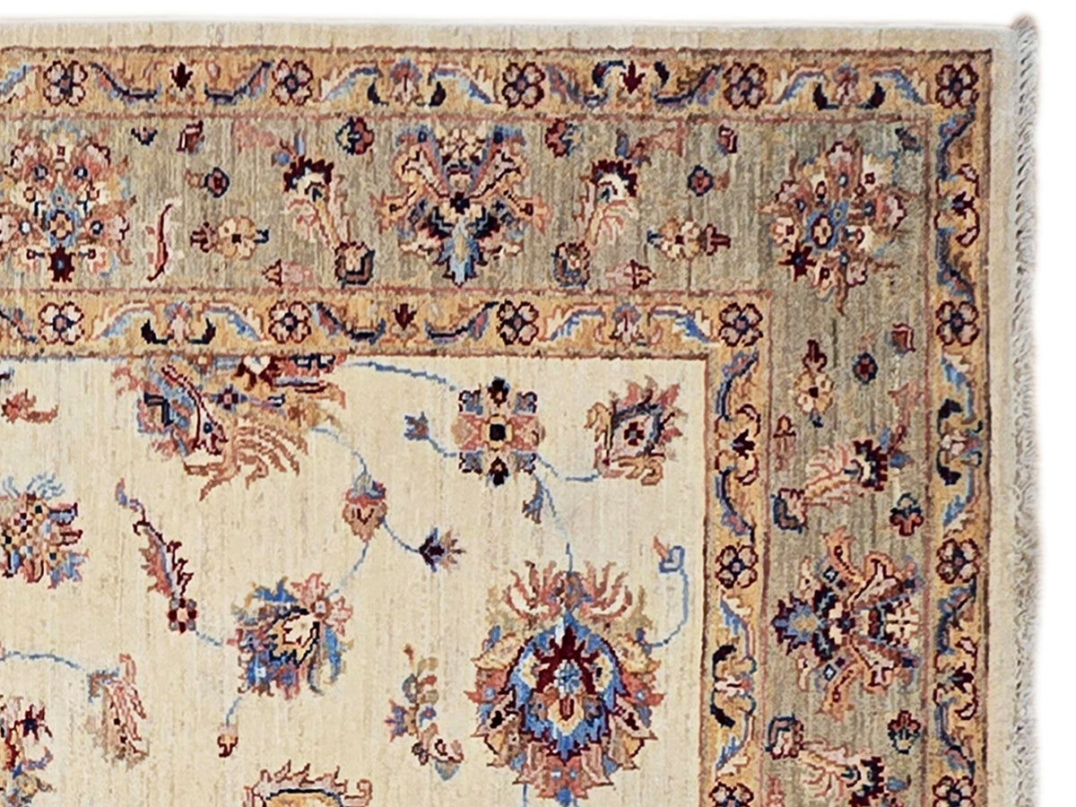 Vintage-style area rug with cream base and ornate blue, red, and tan pattern border