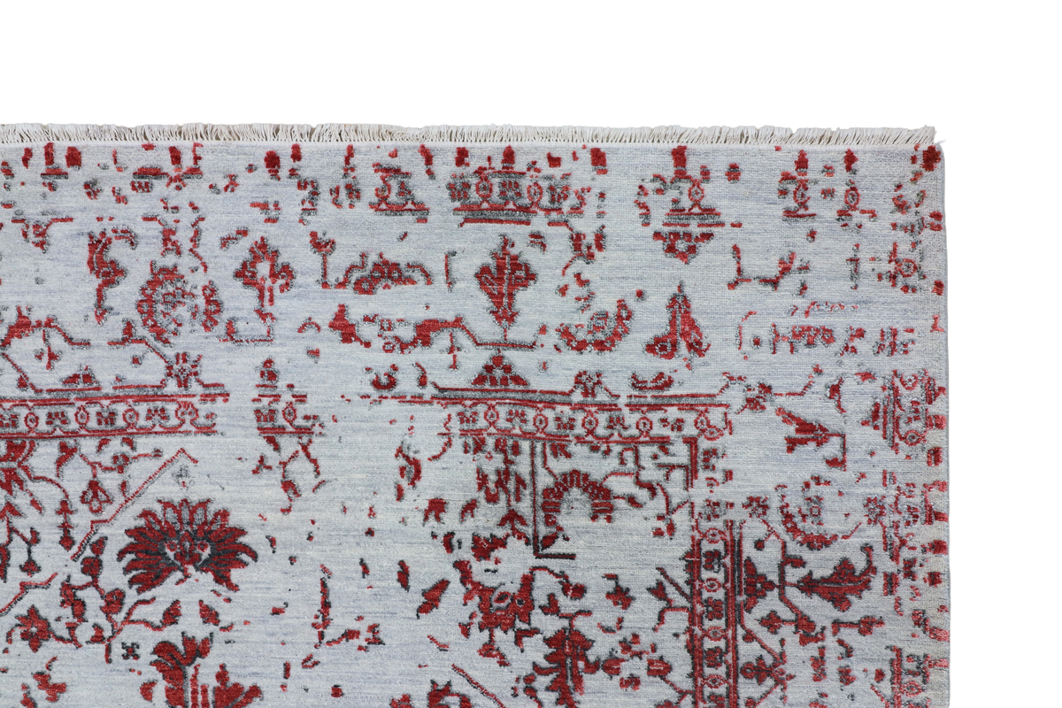 Rug close-up along the top edge with red distressed motifs and border lines