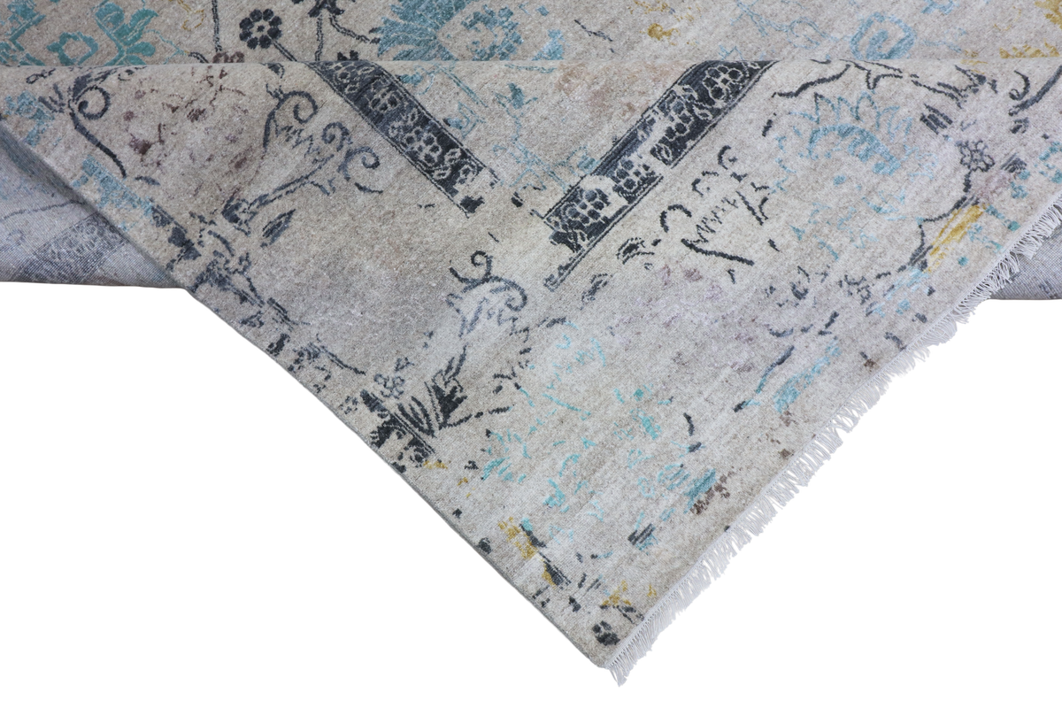 Close-up of light gray rug corner showing blue and yellow motif print and soft fringe.