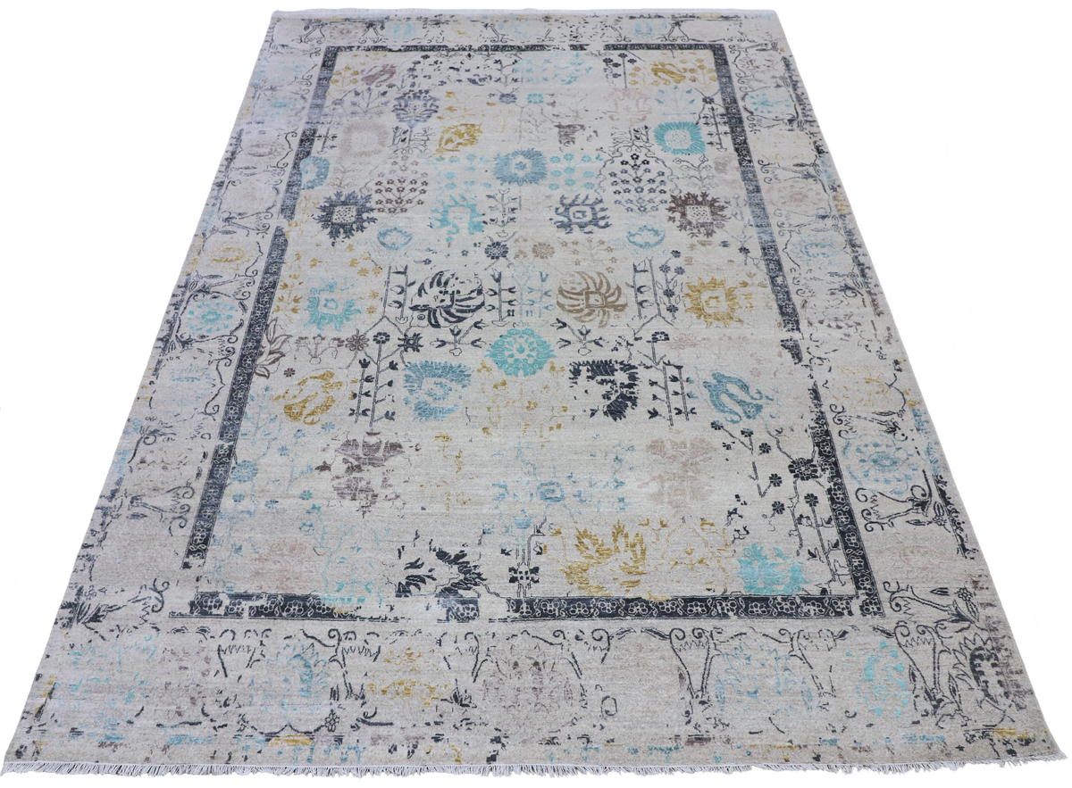 Rectangular light gray area rug with blue, teal, and yellow decorative medallion pattern.