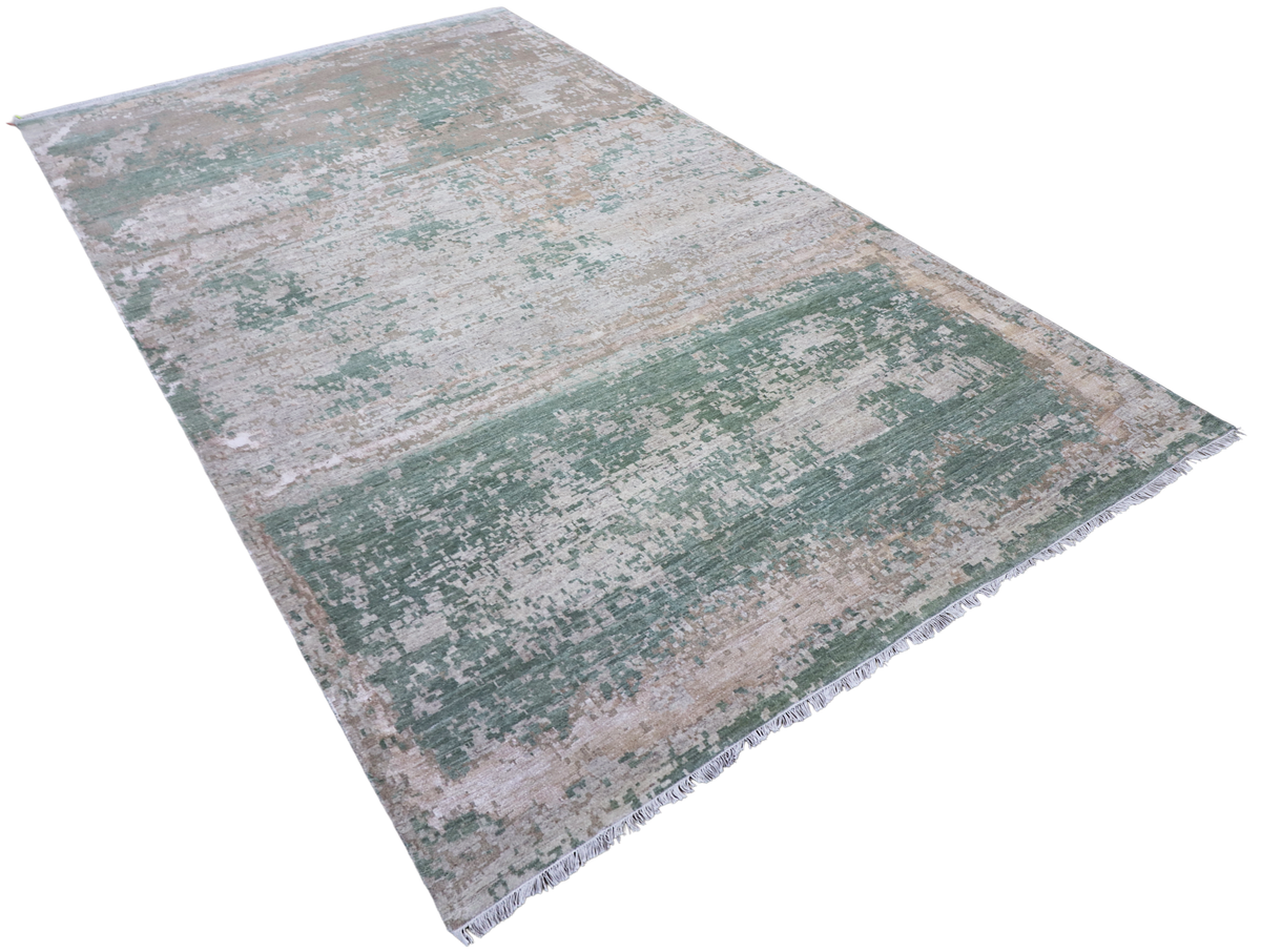 Rectangular modern rug with layered distressed pattern in jade green, beige, and gray
