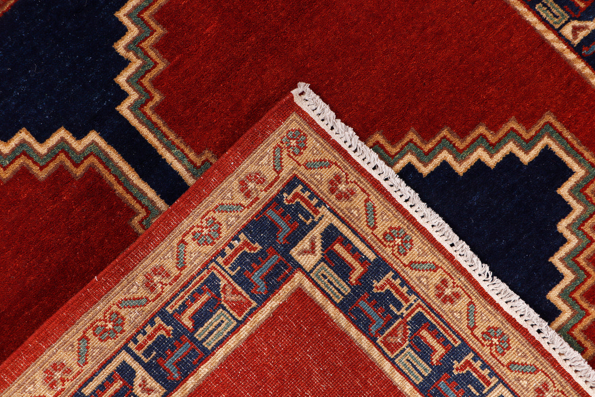 Red rug corner with cream fringe and layered geometric pattern