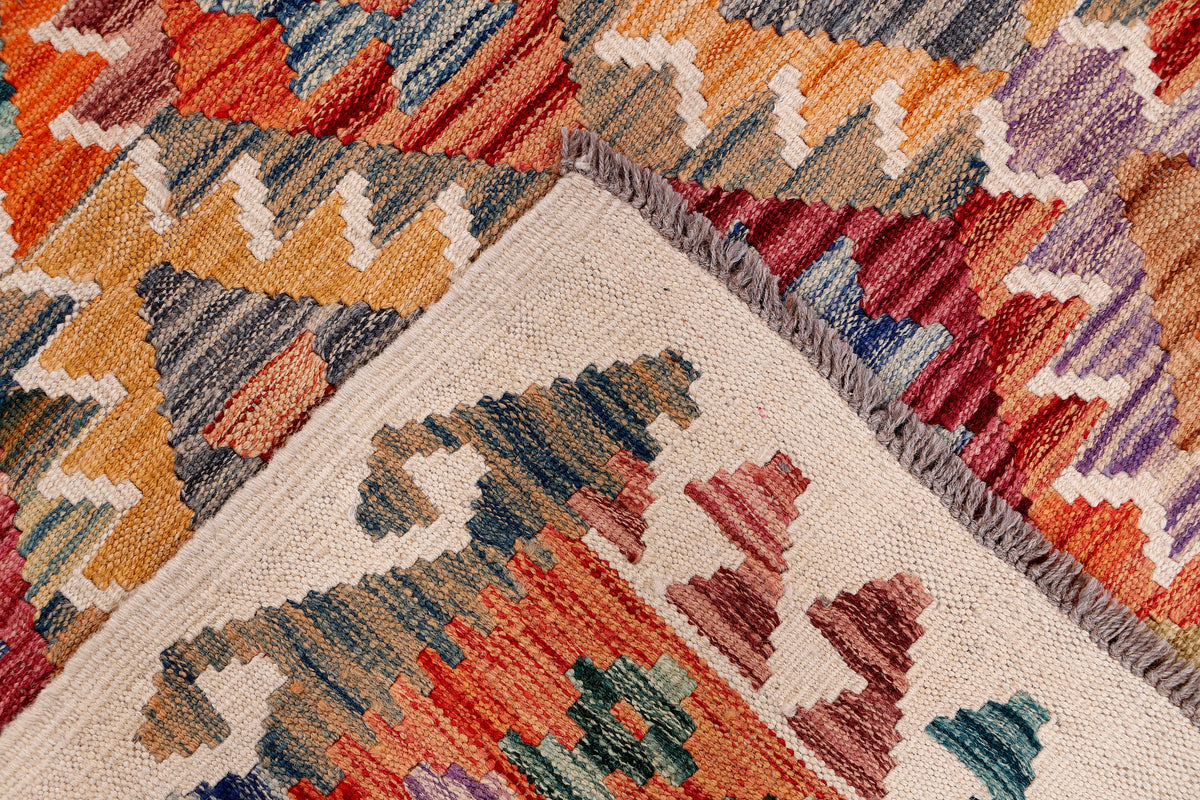 Kilim rug corner with multicolor geometric pattern and short fringed edge