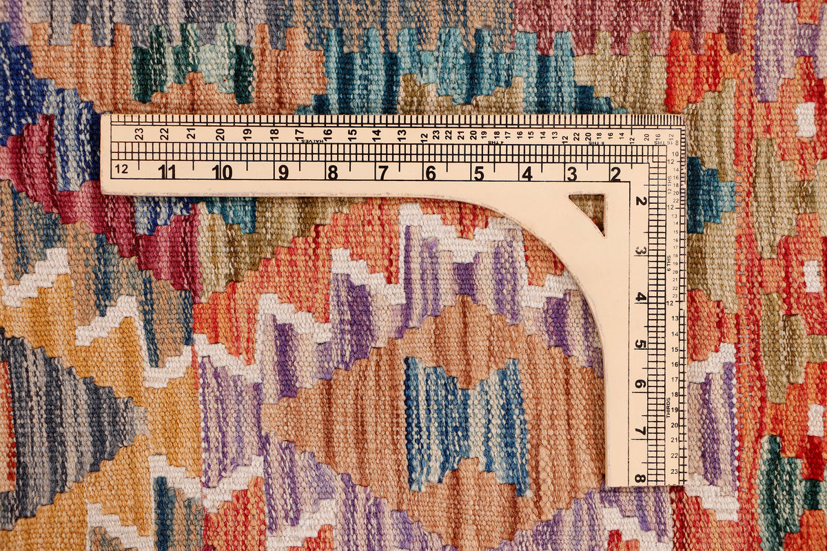 Kilim rug section with measuring ruler over multicolor geometric pattern