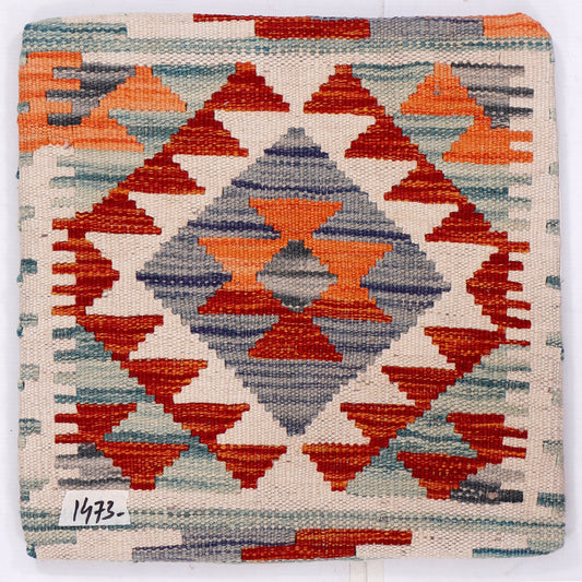 Kilim cushion front close-up, geometric diamonds in orange, red, blue on cream