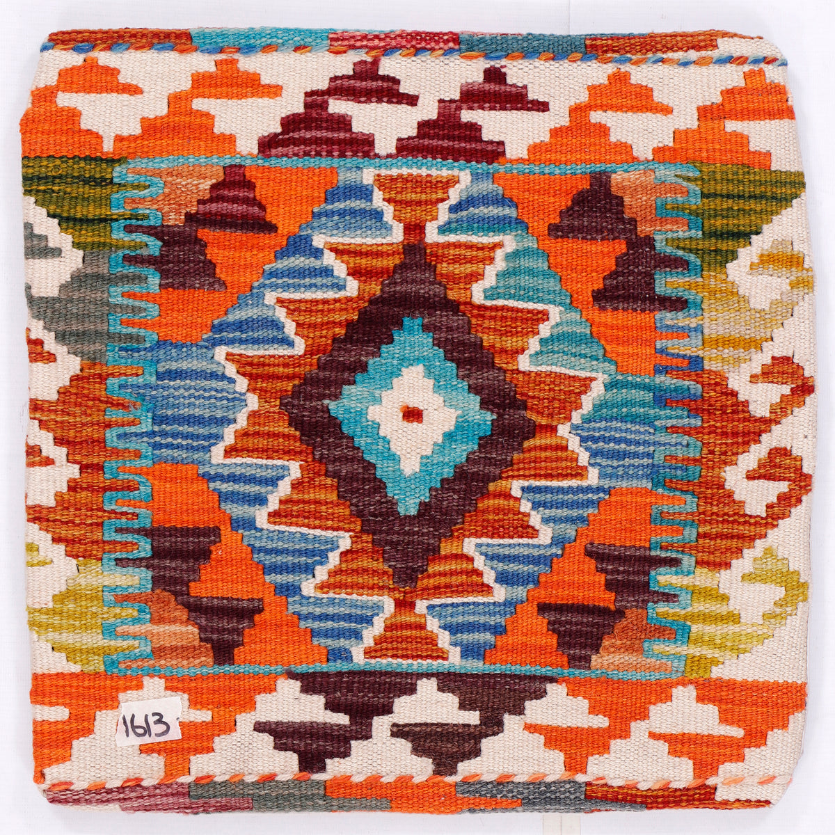Close-up of orange kilim cushion front with multicolor diamond pattern, woven texture