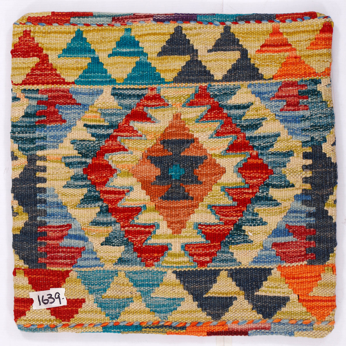 Geometric kilim cushion cover, close-up multicolor diamonds in blue red yellow and cream