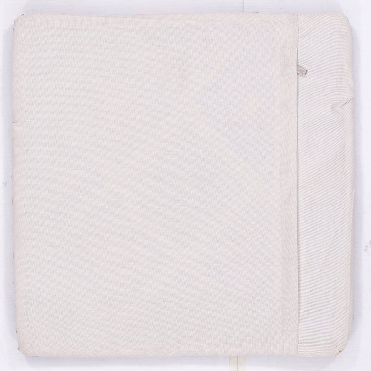 Off-white kilim cushion backing with subtle woven texture and folded edge