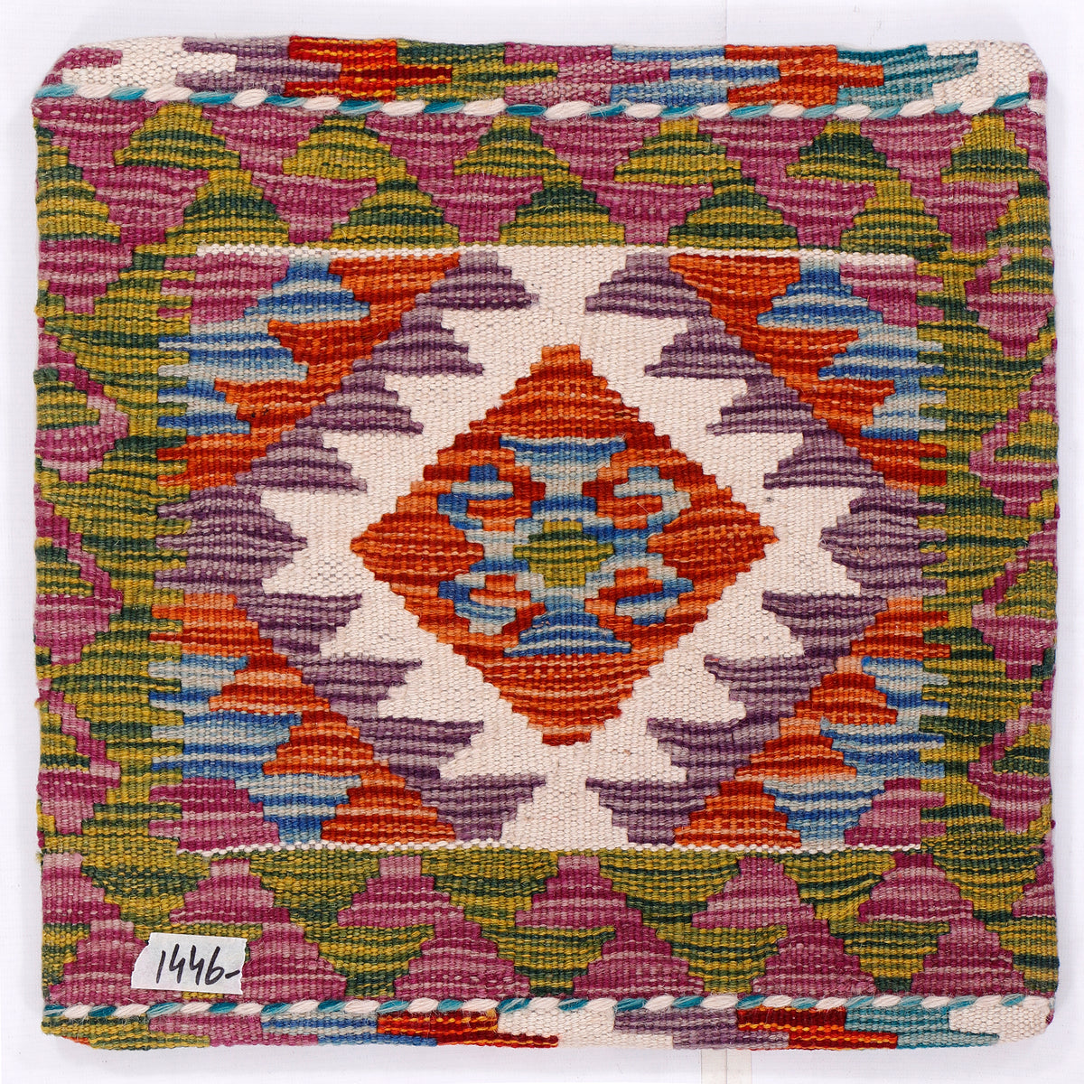 Close-up kilim cushion front with orange medallion and purple, blue, yellow woven pattern
