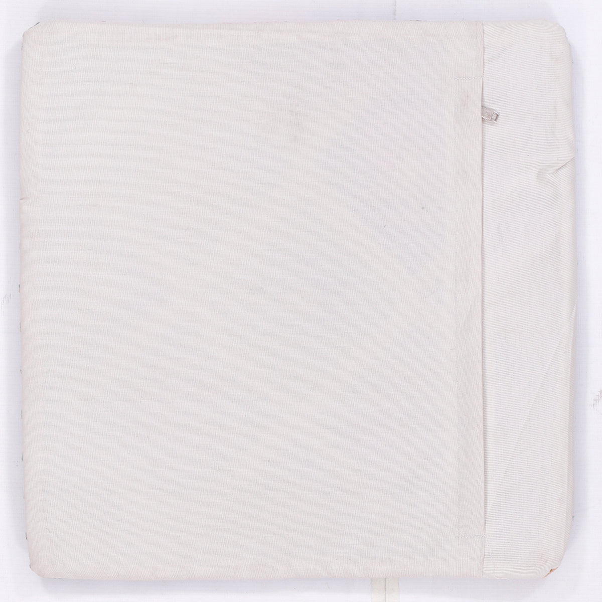Square kilim cushion cover back, off-white with subtle woven texture and concealed seam