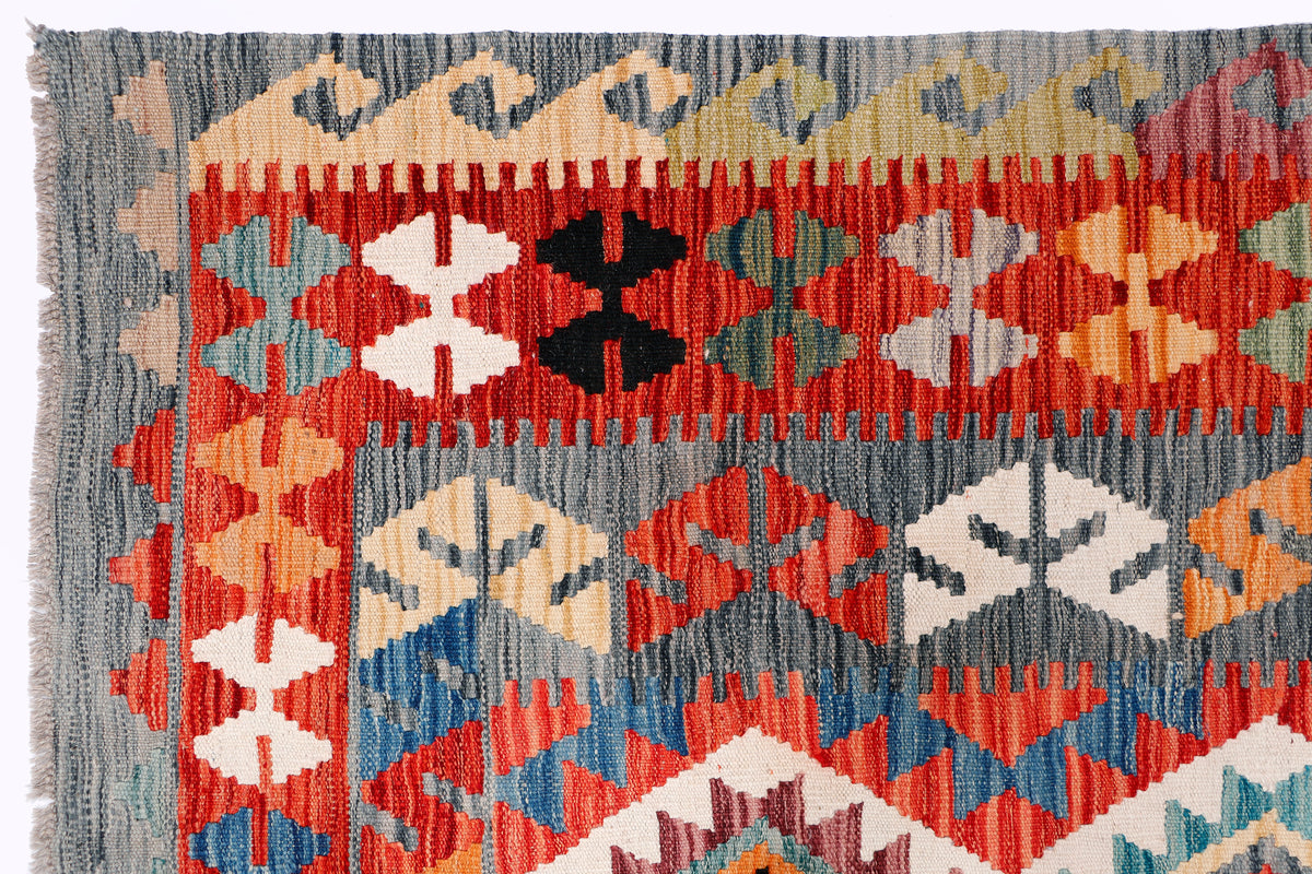 Kilim rug close-up with multicolor geometric pattern and short fringes