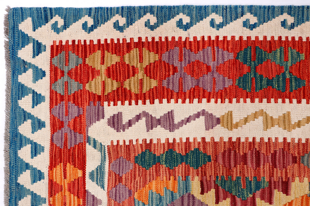 Kilim rug with red, blue, and beige geometric diamond pattern border