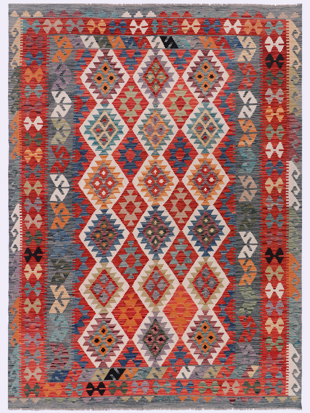 Geometric kilim rug with repeating diamond motifs in red, blue, and cream