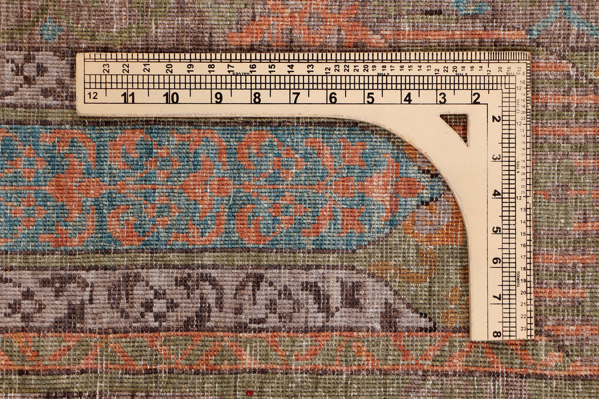 Rug edge and border with ruler measuring width; multicolor rust, teal, olive, beige.