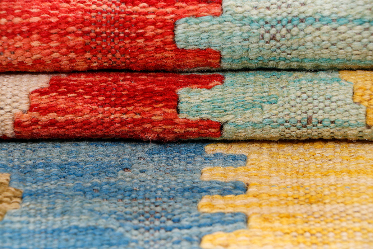 Kilim rug edge detail with woven texture in red, teal, yellow and blue stripes