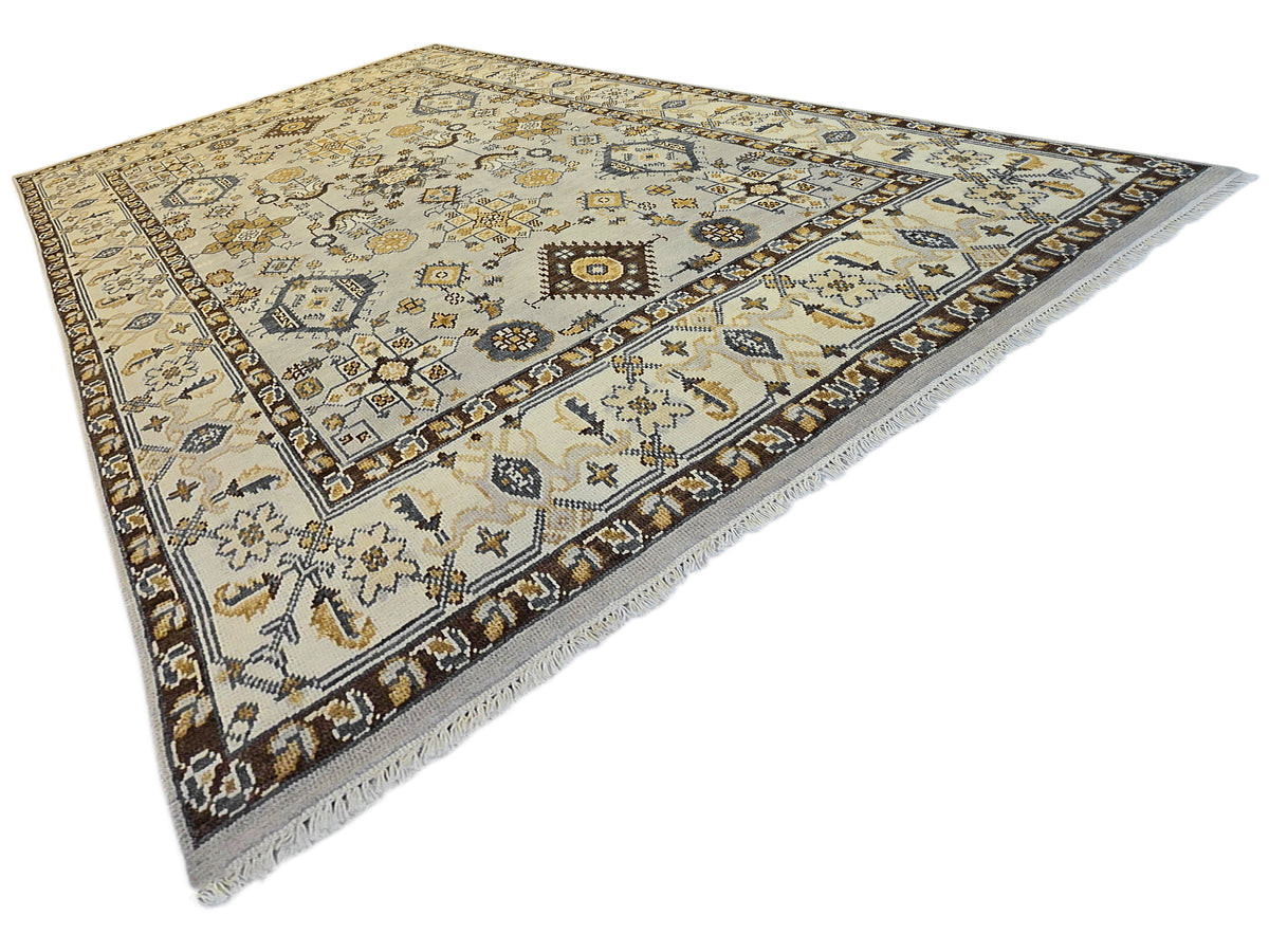 Oushak rug corner view with ivory background, navy and gold crosses and floral geometric motifs.